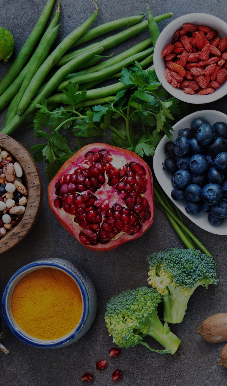 A flat lay of healthy foods: fruits, veggies, fish, nuts, seeds, and more.