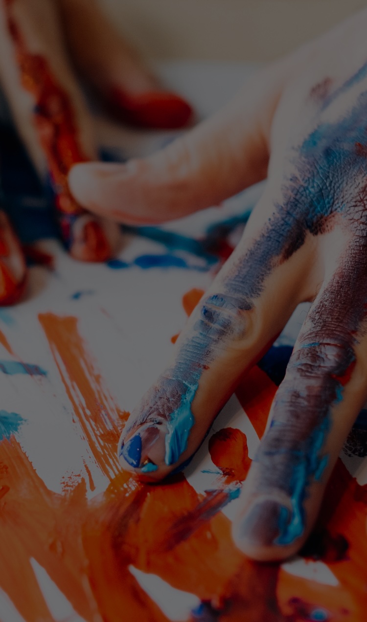 A man finger paints during an art therapy session.