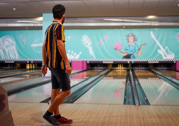 A client waits for the pins to reset at the bowling alley.