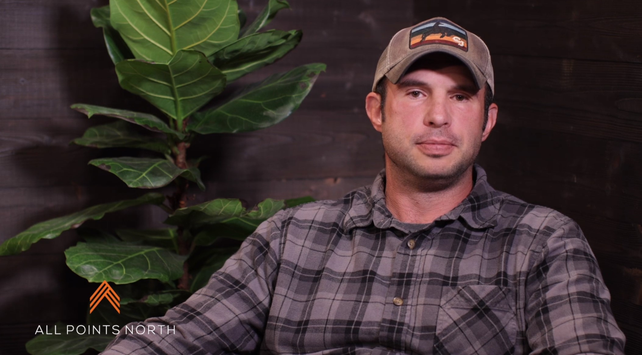 Brandon in hat, talking about Veteran's program to camera