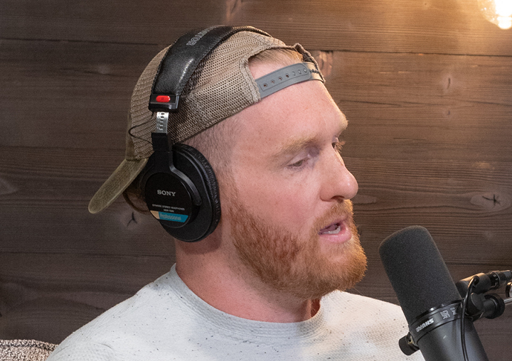 Garrett Gilkey talks into a microphone on The Circle of M podcast.