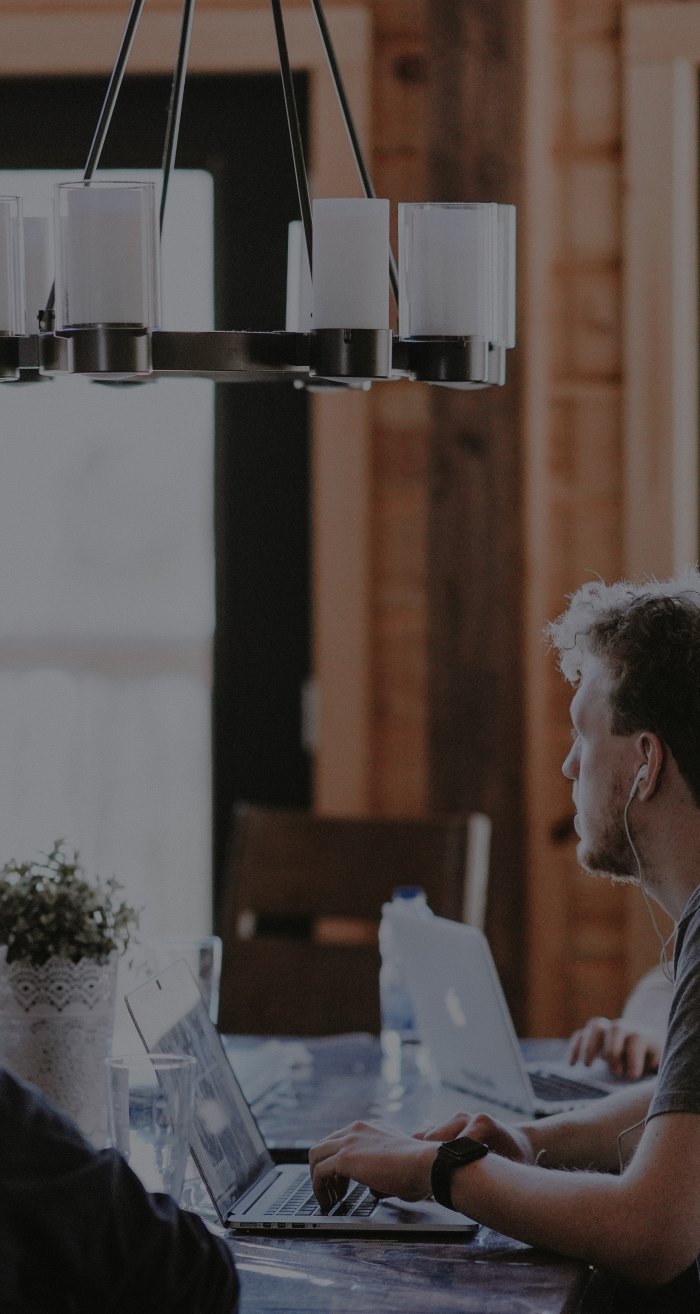 Man in tech sitting around a conference table and looking out the window