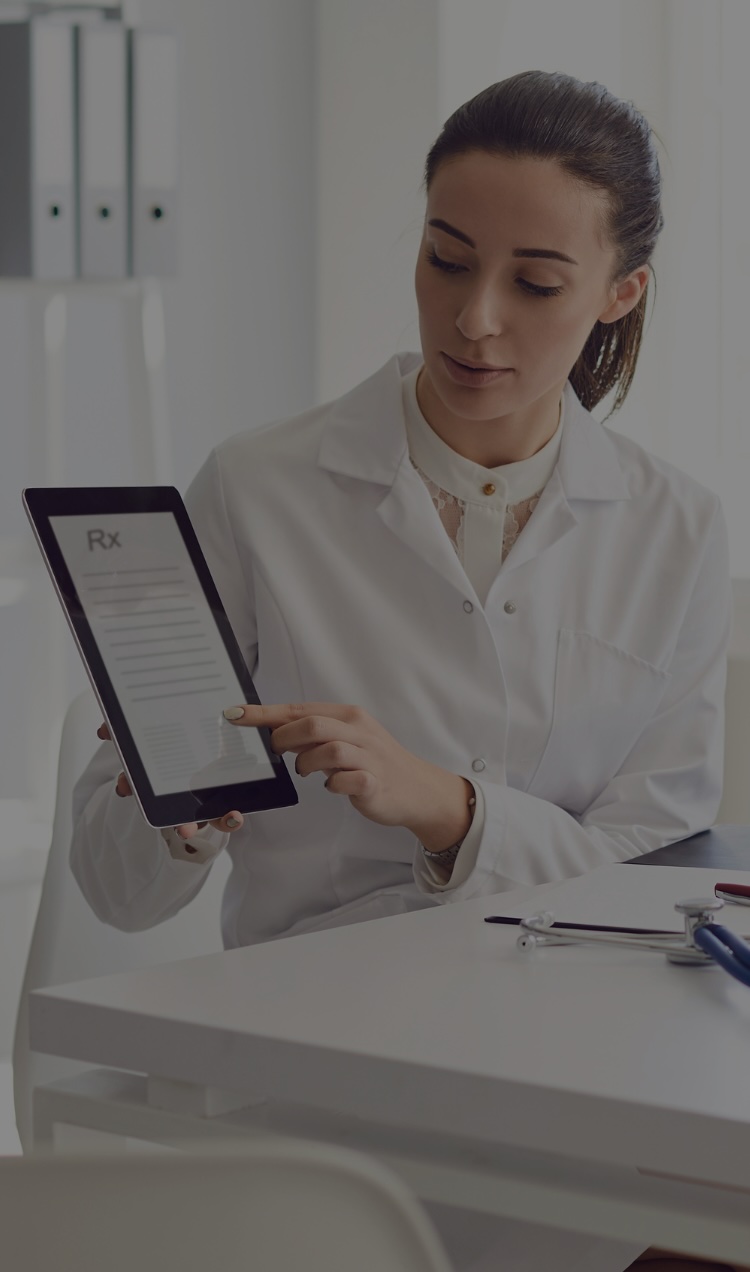 A doctor reviews medication-assisted recovery with a patient with an Rx on a tablet.