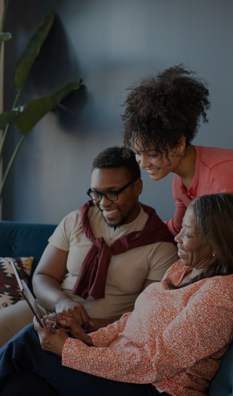 A family gathers around a tablet for a virtual family session.