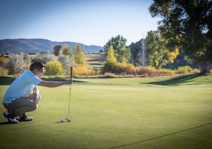 A client sizes up a final shot on the putting green.