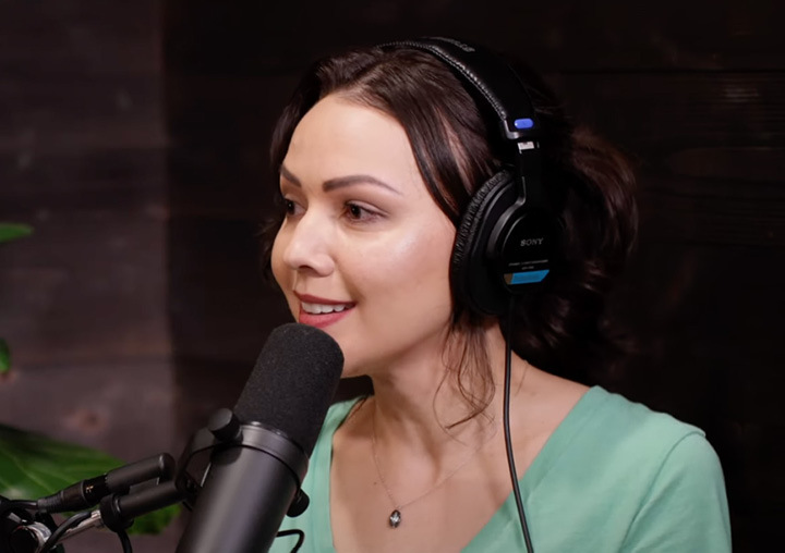 Janessa Ho talks into a microphone on the Harder Than Healing podcast.