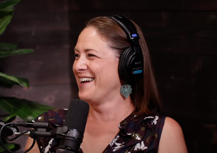Producer Tiffany talks into a microphone on the Harder Than Healing podcast.