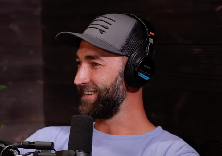 Kyle Quincey talks into a microphone on the Harder Than Healing podcast.