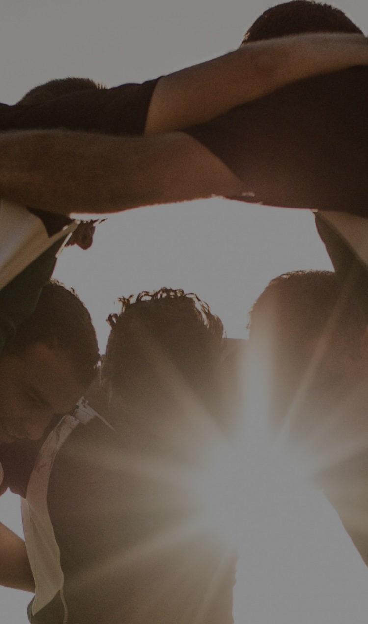 A team huddles on a playing field.