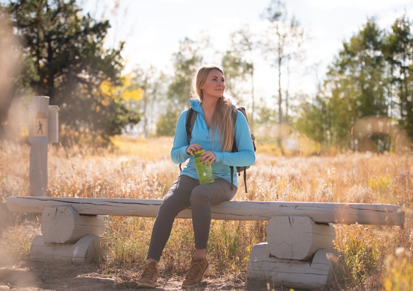 A woman takes a break after hiking on a trail in Colorado.