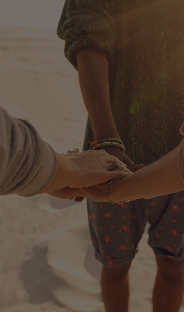 A group of friends puts their hands in together in support of each other.