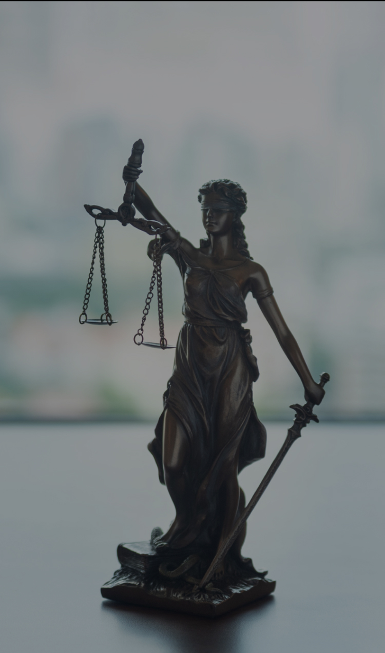 A figurine of Lady Justice sits on a lawyer's desk.