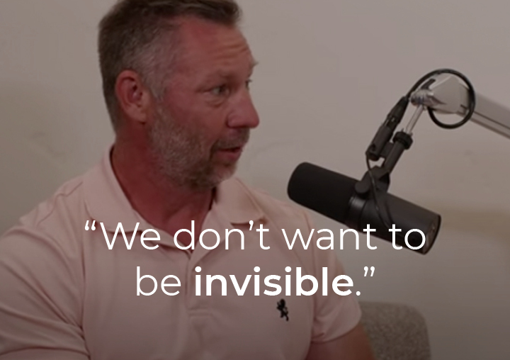 John Hardman speaking into a podcast microphone with a text overlay: 
