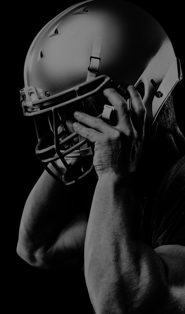 A football player removing his helmet.