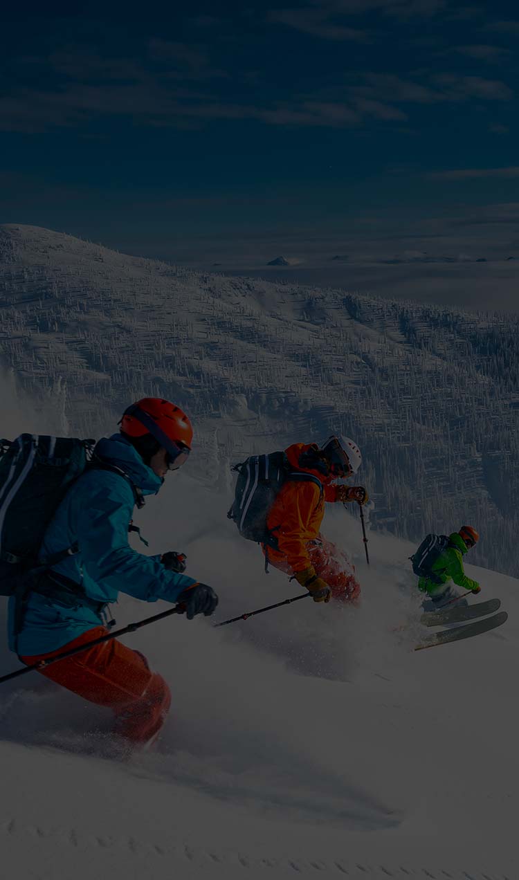 Three people skiing and snowboarding down a mountain