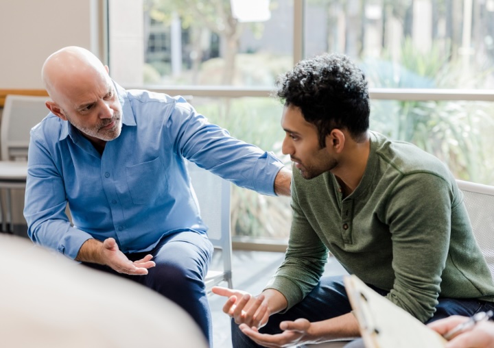 A therapist supports a client during a trauma therapy session.