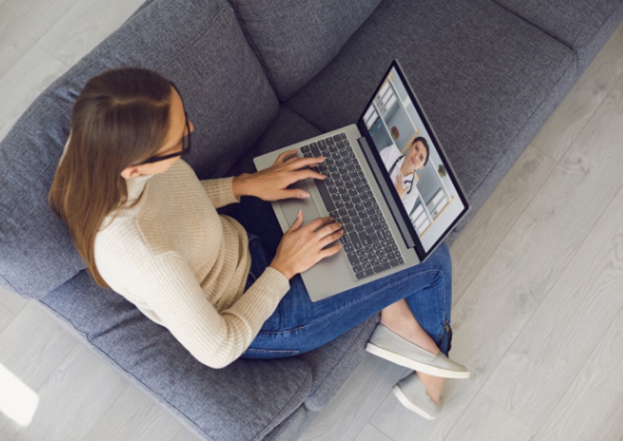 A woman on a couch while using an online mental health service