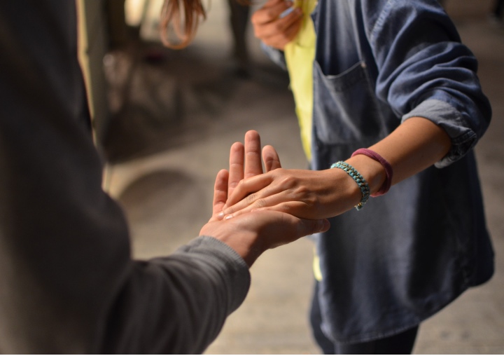 Two people reaching out to grasp each others hands.