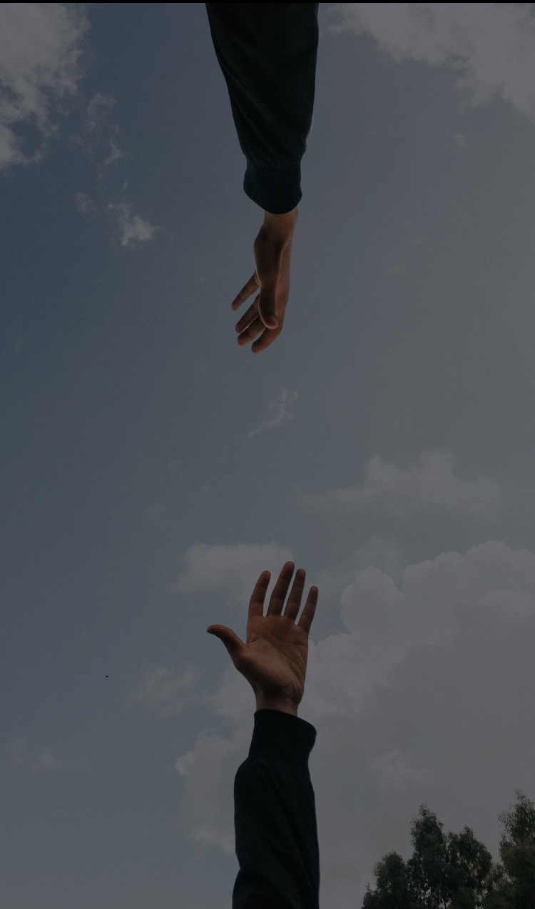 Two people reaching out their hands toward each other.