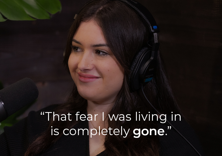 Dahbra speaking into a podcast microphone with a text overlay: That fear that I was living in is completely gone.