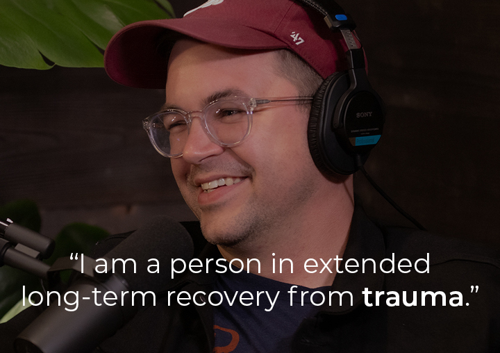 Elliott speaking into a podcast microphone with a text overlay: I am a person in extended long-term recovery from trauma.