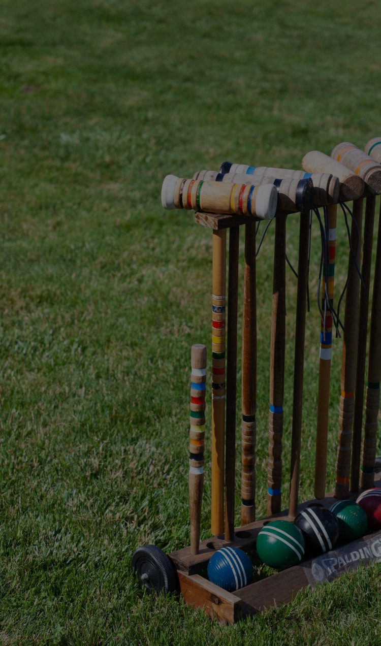 Croquet mallets and balls stored on the lawn.