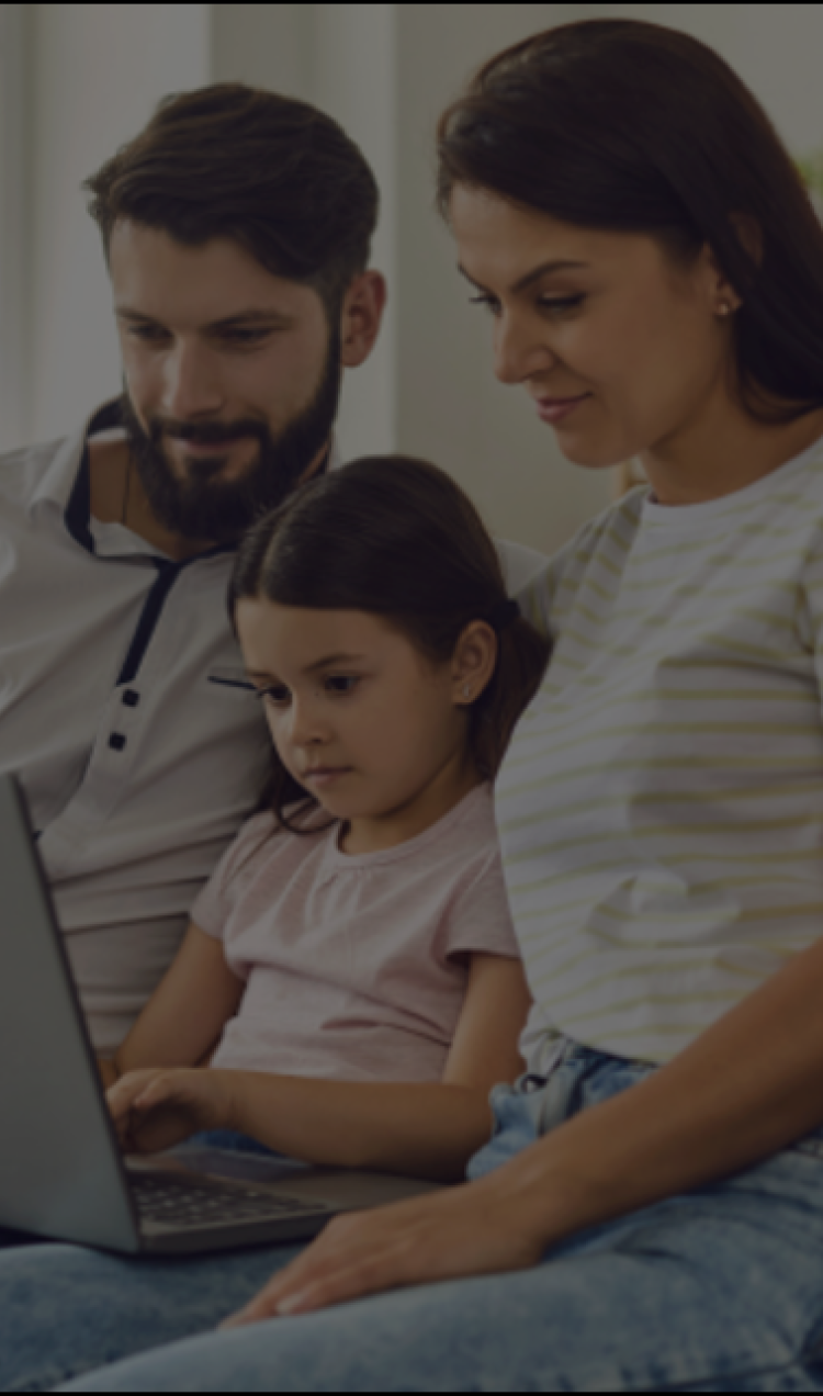 young couple looking at a computer with their daughter