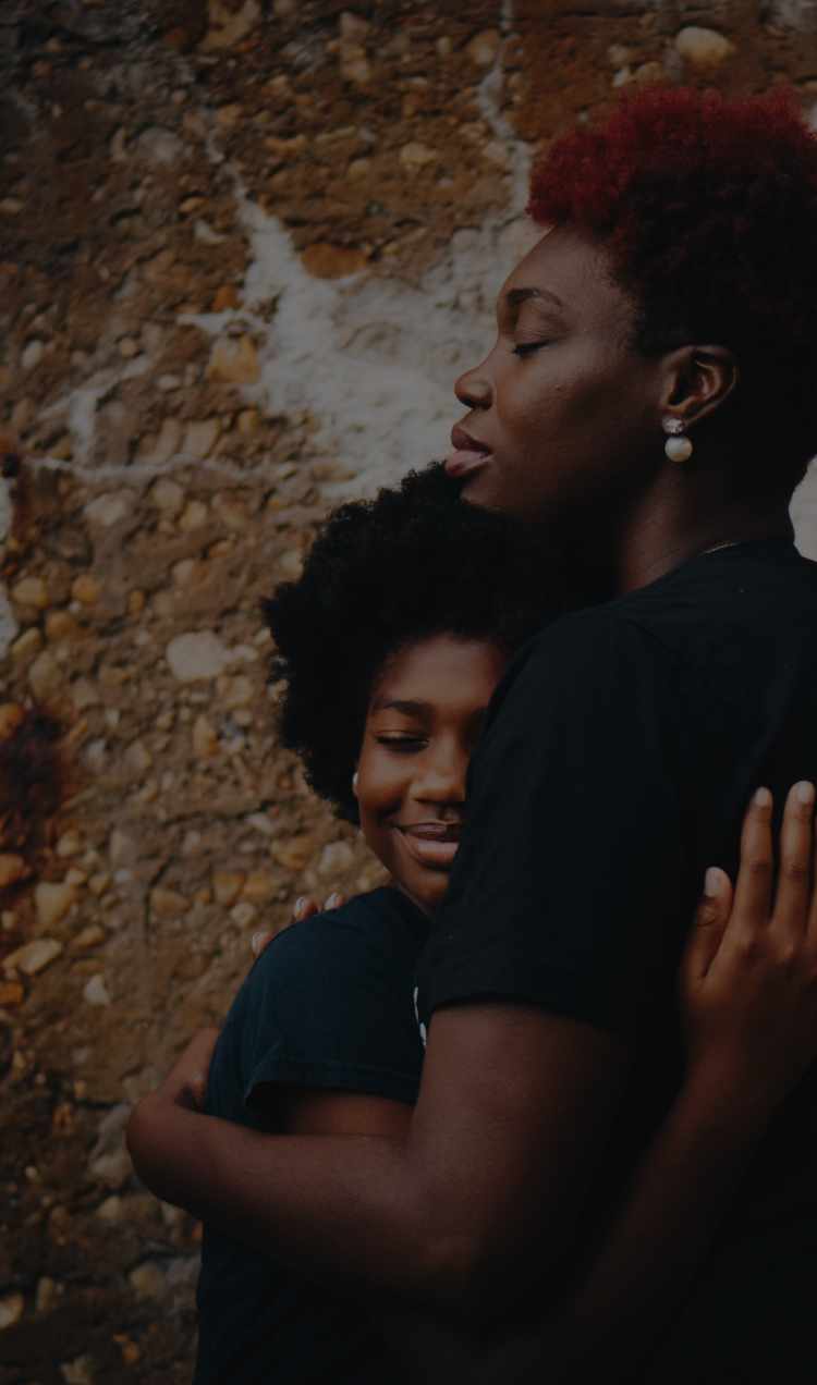 A mother and daughter embrace each other for a hug.