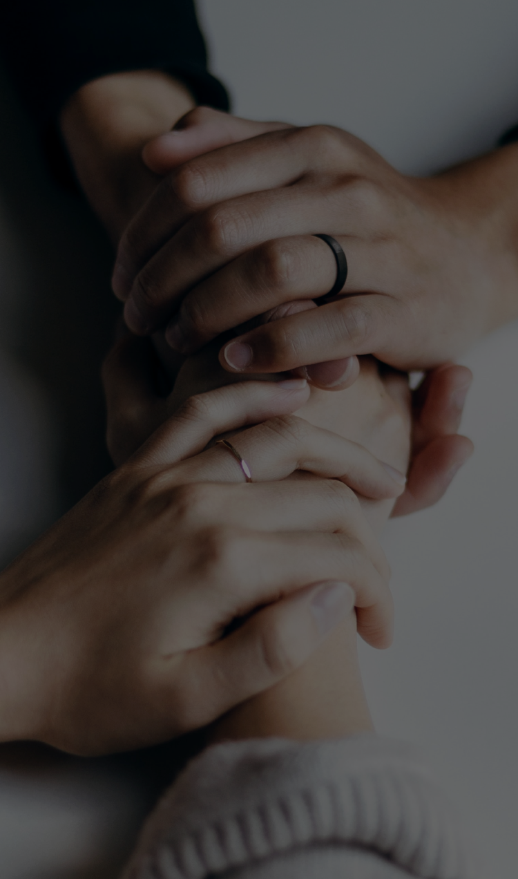 Two people hold hands across a table.